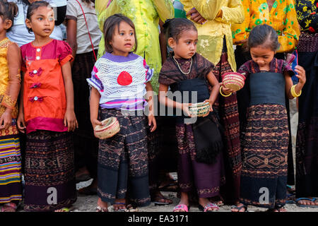 Kinder warten auf ankommende Gäste während einer traditionellen Begrüßungszeremonie in Lamagute Dorf, Lembata, Indonesien. Stockfoto