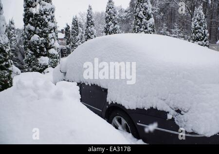 schwarzes Auto unter großen Neuschnee Stockfoto