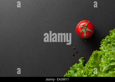 rote Tomaten mit grünem Salat Stockfoto