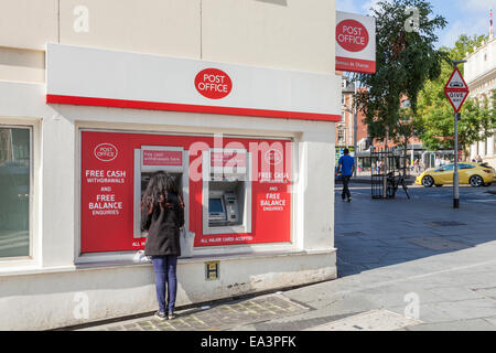 Frau mit einem Post ATM Bargeldbezug Maschine, Nottingham, England, Großbritannien Stockfoto