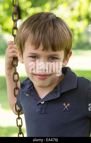 Kleiner Junge spielt im Garten Schaukel, USA Stockfoto