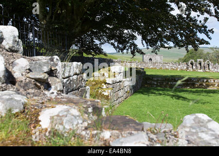 Hermitage Castle, Schottland. Zerstörten Überreste Hermitage Kapelle und Friedhof mit Kapelle Burg im Hintergrund. Stockfoto