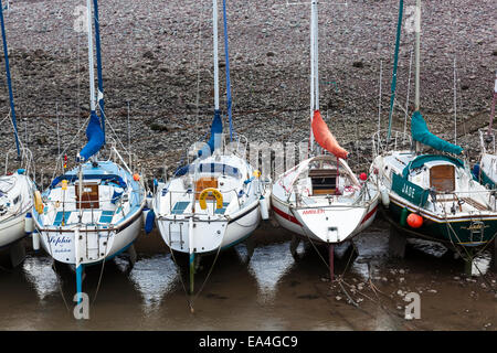 Segelboote Rest sanft auf Sand, Schlamm und Felsen bei Ebbe im kleinen Hafen von Porlock Weir, Somerset. Stockfoto