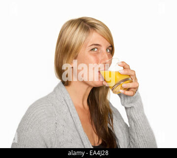 junge Frau mit einem Glas frisch gepressten Orangensaft, weißer Hintergrund Stockfoto