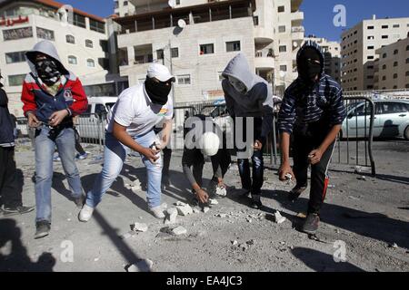 Jerusalem, Jerusalem, Palästina. 6. November 2014. Palästinensische Jugendliche Steinwurf gegen israelische Sicherheitskräfte während der Zusammenstöße im palästinensischen Flüchtlingslager Schuafat in Ost-Jerusalem, am 6. November 2014. Israel hat keine Pläne, den Status Quo in Jerusalem Flashpoint Al-Aqsa Moschee zusammengesetzte ändern indem es jüdische Gebet es erlaubt, Premierminister Benjamin Netanyahu sagte Jordaniens König Abdullah II Credit: Muammar Awad/APA Bilder/ZUMA Draht/Alamy Live News Stockfoto