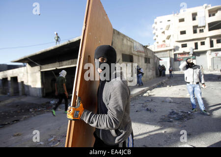 Jerusalem, Jerusalem, Palästina. 6. November 2014. Maskierte palästinensische Jugendliche benutzen Türen als Schild bei Zusammenstößen mit israelischen Sicherheitskräften in die palästinensischen Flüchtlingslager Schuafat in Ost-Jerusalem, am 6. November 2014. Israel hat keine Pläne, den Status Quo in Jerusalem Flashpoint Al-Aqsa Moschee zusammengesetzte ändern indem es jüdische Gebet es erlaubt, Premierminister Benjamin Netanyahu sagte Jordaniens König Abdullah II Credit: Muammar Awad/APA Bilder/ZUMA Draht/Alamy Live News Stockfoto