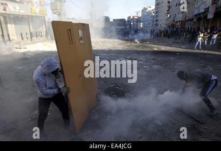 Jerusalem, Jerusalem, Palästina. 6. November 2014. Maskierte palästinensische Jugendliche benutzen Türen als Schild bei Zusammenstößen mit israelischen Sicherheitskräften in die palästinensischen Flüchtlingslager Schuafat in Ost-Jerusalem, am 6. November 2014. Israel hat keine Pläne, den Status Quo in Jerusalem Flashpoint Al-Aqsa Moschee zusammengesetzte ändern indem es jüdische Gebet es erlaubt, Premierminister Benjamin Netanyahu sagte Jordaniens König Abdullah II Credit: Muammar Awad/APA Bilder/ZUMA Draht/Alamy Live News Stockfoto