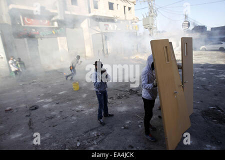 Jerusalem, Jerusalem, Palästina. 6. November 2014. Maskierte palästinensische Jugendliche benutzen Türen als Schild bei Zusammenstößen mit israelischen Sicherheitskräften in die palästinensischen Flüchtlingslager Schuafat in Ost-Jerusalem, am 6. November 2014. Israel hat keine Pläne, den Status Quo in Jerusalem Flashpoint Al-Aqsa Moschee zusammengesetzte ändern indem es jüdische Gebet es erlaubt, Premierminister Benjamin Netanyahu sagte Jordaniens König Abdullah II Credit: Muammar Awad/APA Bilder/ZUMA Draht/Alamy Live News Stockfoto