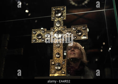 Prag, Tschechische Republik. 6. November 2014. Ein Besucher untersucht eine romanischen Reliquienschrein Prozession Kreuz während einer Pressevorschau auf die Ausstellung der Benediktiner im Herzen Europas in der Nationalgalerie in Prag, Tschechien. Die Ausstellung mit dem Titel öffnen das Tor des Paradieses bietet eine exzellente Auswahl an frühen mittelalterlichen Artefakte aus dem Jahr 800 bis 1300. Dieses Reliquiar Prozession Kreuz von Roudnice wurde Mitte des 12. Jahrhunderts in Prag oder Swabia gemacht und gehört heute zu den Lobkowicz-Sammlung. Stockfoto