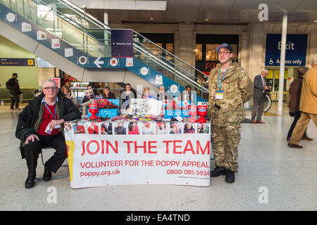 Freiwillige verkauf Mohnblumen für die Poppy Aufruf zum Tag der Erinnerung an eine Bahnhofshalle stall in Waterloo, London Stockfoto