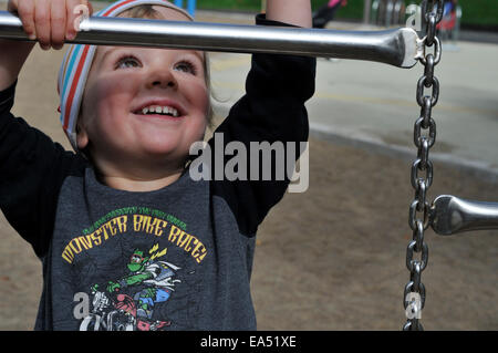 Ein kleiner Junge (2 1/2 Jahre) ein Aufstieg auf einem Klettergerüst Stockfoto