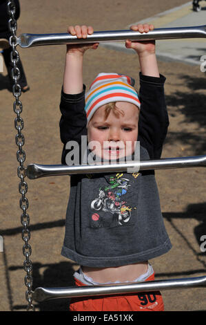 Ein kleiner Junge (2 1/2 Jahre) ein Aufstieg auf einem Klettergerüst Stockfoto