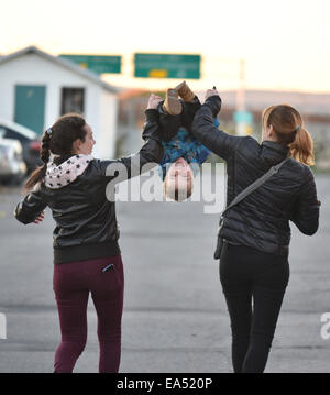 Eine zwei Jahre alte geworfen in der Luft von zwei Frauen Stockfoto