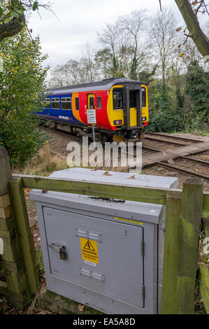 East Midlands Zug überfahren einen öffentlichen Fußweg mit Warnschild und eine graue elektrische Abzweigdose. Stockfoto