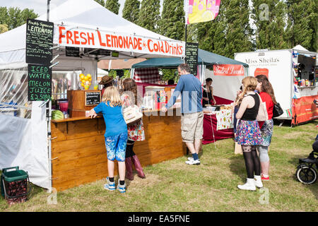 Menschen warten in der Schlange für Getränke an einem hausgemachte Limonade Stand auf einen englischen Sommer fair. Stockfoto