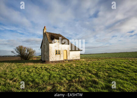 Ein einsames Reetdachhaus gesehen von der Straße in Nord-Norfolk, England. Stockfoto