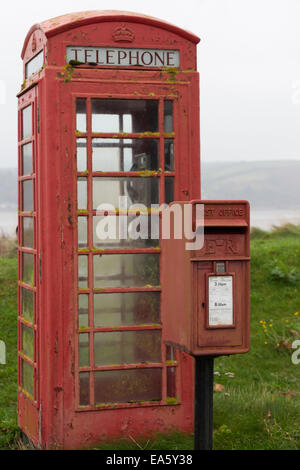 Stehen einem verwitterten roten Briefkasten und Telefonzelle in der Nähe der Tywi-Mündung bei Llansteffan, Carmathenshire, Wales, UK Stockfoto