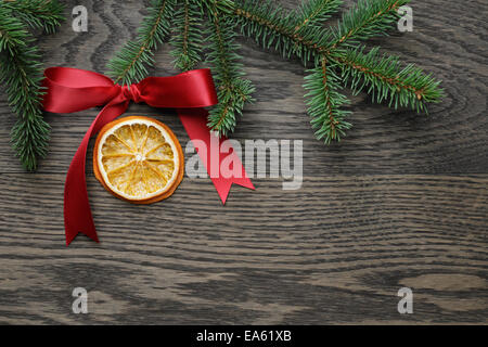 Fichte Zweig mit roter Schleife und Orangenscheibe, Weihnachten Hintergrund Stockfoto