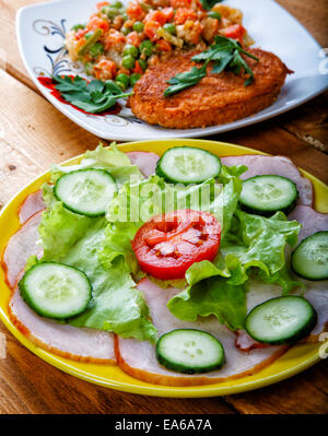 Gemüsesalat und Schnitzel auf einem ländlichen Tisch Stockfoto