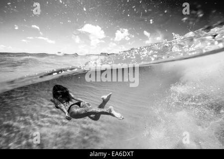 Frau schwimmend unter Wasser im Meer Stockfoto