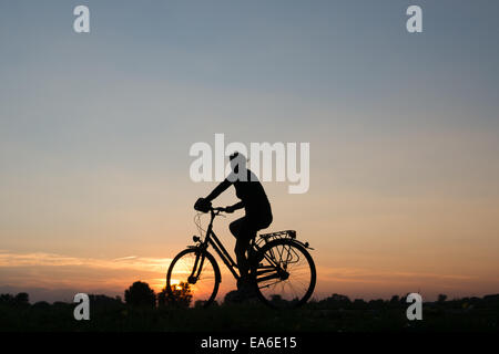 Deutschland, Nordrhein-Westfalen, Radfahren bei Sonnenuntergang entlang Rhein River Stockfoto