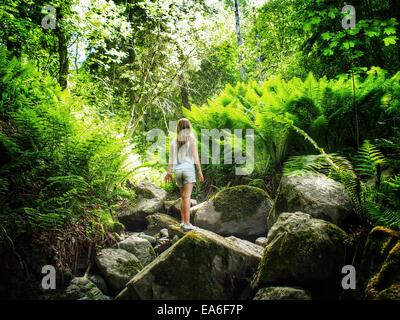 Mädchen auf Felsen im Wald, Dalarna, Schweden Stockfoto