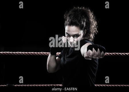 Porträt einer Boxerin, die in einem Boxring trainiert Stockfoto