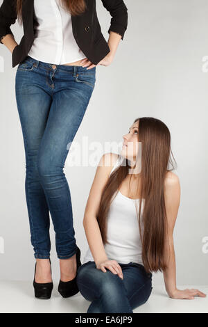 Mädchen sitzen neben dem Mädchen Füße Stockfoto