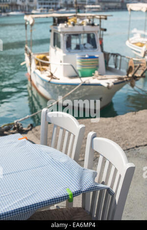 Typisch griechische Restaurant und Fisch-Boot auf dem Hintergrund Stockfoto