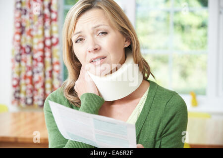 Frau liest Brief nach Erhalt Nackenverletzung Stockfoto