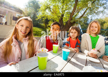 Internationale Kinder trinken Tee und Essen Muffins Stockfoto