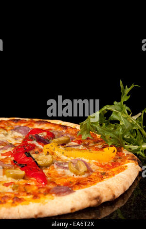 Pizza mit Belag rote und gelbe Paprika, rote Zwiebel, Käse und grüne Oliven Stockfoto