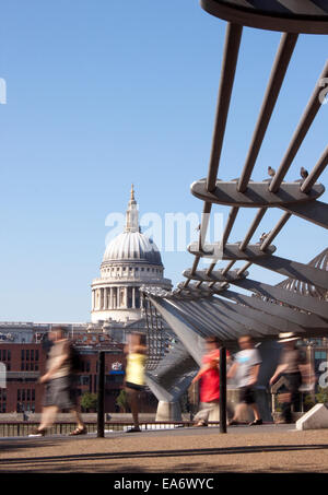 Ein Blick auf die Kuppel der St. Pauls Cathedral über die Themse mit Bewegung verwischt Touristen zu Fuß unter Millennium Bridge Stockfoto