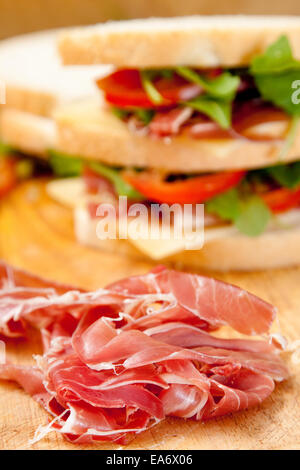 dünne Scheiben von italienischen Schinken mit weißen Bloomer Brot Sandwich-Schinken, Greyerzer Käse, Tomatenscheiben und Rakete Stockfoto