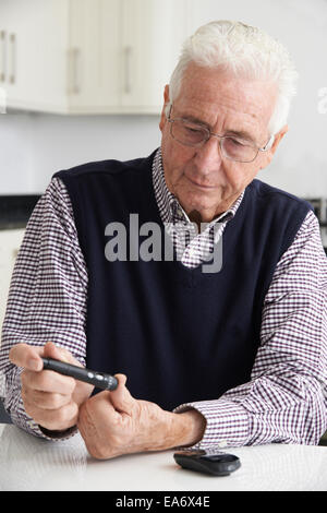 Senior woman Kontrolle des Blutzuckerspiegels zu Hause Stockfoto