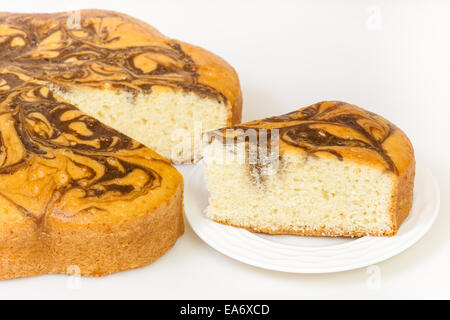 Eine Detailansicht ein Marmorkuchen und seine Scheibe. Der Marmorkuchen ist ähnlich wie Sandkuchen aber zufällige Schokolade Wirbel drauf hat. Stockfoto