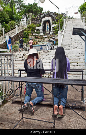 Zwei katholische Filipina Frauen beten in der Dame von Lourdes Schrein in Baguio, Philippinen. Stockfoto