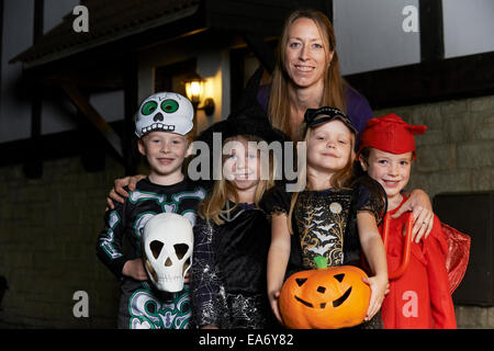 Halloween-Party mit Kinder Süßes oder Saures In Tracht mit Mutter Stockfoto