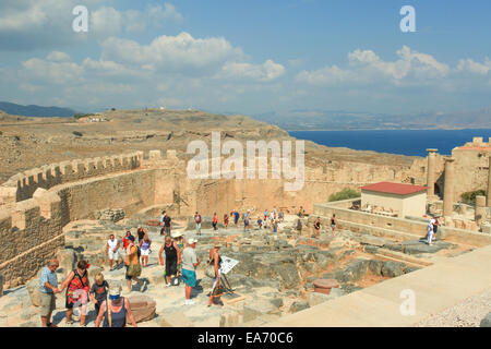 Touristen an der Spitze der antiken Akropolis von Lindos Ruinen, eine natürliche Zitadelle, die nacheinander von den Griechen, die Rom befestigt wurde Stockfoto