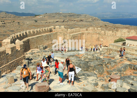 Touristen an der Spitze der antiken Akropolis von Lindos Ruinen, eine natürliche Zitadelle, die nacheinander von den Griechen, die Rom befestigt wurde Stockfoto