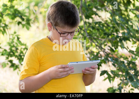 Der junge in Brille schaut Natur Tablet-computer Stockfoto