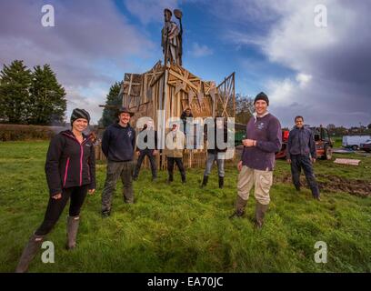 Lewes, UK. 7. November 2014. Die Lagerfeuer-Skulptur für East Hoathly 90. Erinnerung Lagerfeuer Nacht nähert sich Fertigstellung. Hunderte von Zuschauern sollen Linie, die Straßen von der kleinen East Sussex Dorf von East Hoathly in der Nähe von Lewes, UK, Watch Feuer Banner in Flammen als einen Akt der Erinnerung auf dem Weg in eine riesige Holzskulptur Lagerfeuer und Feuerwerk Anzeige durchgeführt. Die Skulptur stellt zwei der Dorfbewohner das Dorf zu verlassen, zu Beginn des ersten Weltkriegs dar. Abgebildet sind ein Teil des Teams, die die Skulptur mit dem Künstler Keith Pettit rechts vom Zentrum gebaut. Bildnachweis: Jim Holden/Alamy Live-Nachrichten Stockfoto