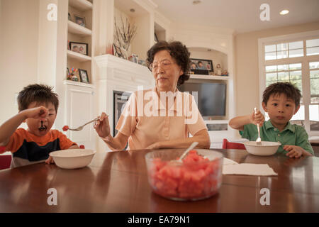 Großmutter mit zwei Enkel (2-3, 4-5) im Speisesaal Stockfoto