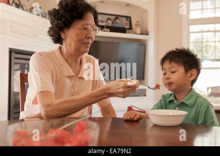 Großmutter Fütterung Enkel im Speisesaal (4-5) Stockfoto