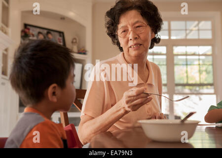 Großmutter mit Enkel (2-3) sitzen im Speisesaal Stockfoto