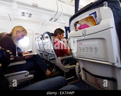 Frau liest ein Buch im Flugzeug Stockfoto