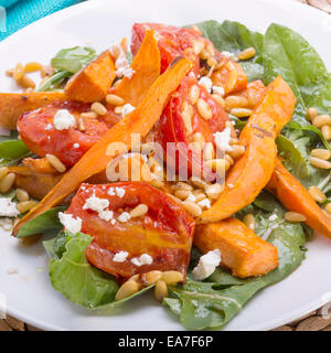 Braten Sie-Kürbis-Salat mit Tomaten, Pinienkerne, Schafskäse und dressing Stockfoto