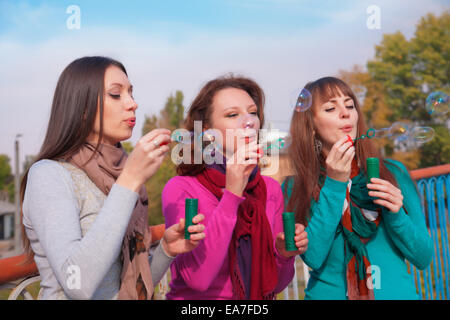 Drei junge schöne Frauen sprengen Luftblasen Stockfoto