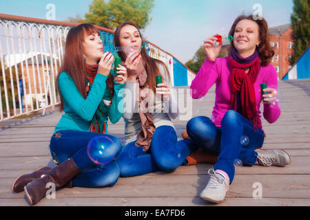 Drei junge schöne Frauen sprengen Luftblasen Stockfoto