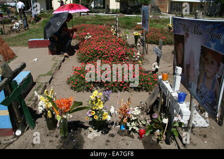 Palo, Philippinen. 8. November 2014. Familienmitglieder besuchen das Grab ihrer Liebe diejenigen, die vor einem Jahr in San Joaquin, Palo, Leyte umgekommen sind. San Joaquin in Palo, Leyte ist eines der härtesten Kollisionsbereich durch Taifun Haiyan vor einem Jahr. Mit Sturmfluten erreicht angeblich zwanzig Fuß starben Hunderte von Menschen während der ersten Stunde des Sturms. Bildnachweis: J Gerard Seguia/Pacific Press/Alamy Live-Nachrichten Stockfoto